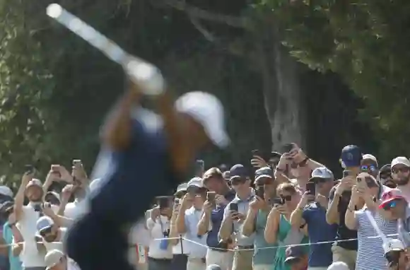 Spectators watch as Tiger Woods tees off on the thirteenth hole during the second round of the 124th U.S. Open golf cham