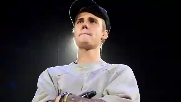 Justin Bieber stands on stage with his arms crossed in November 2015.