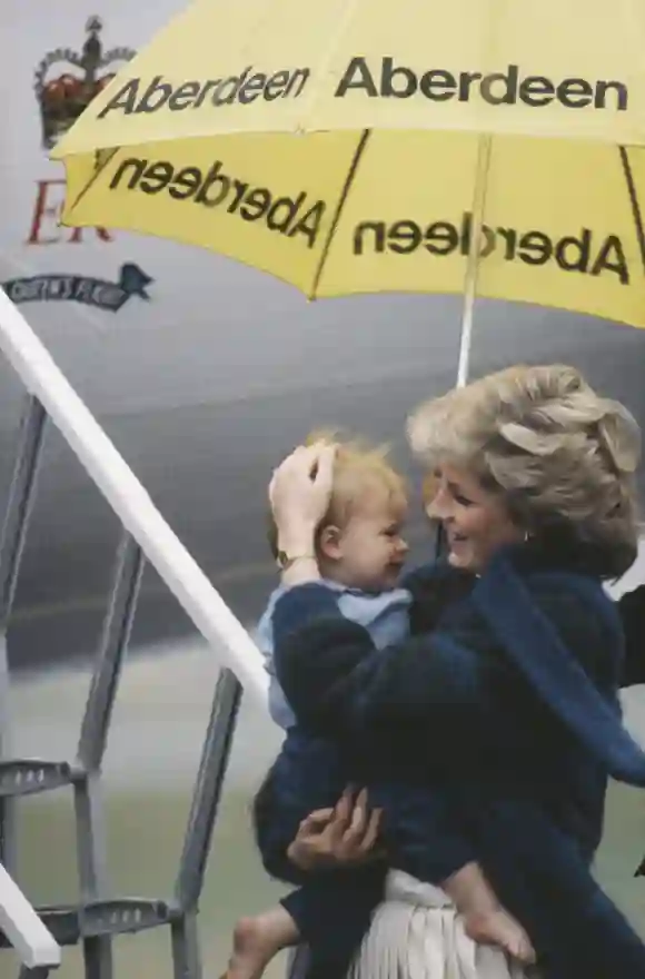 La Princesa Diana cubriendo al pequeño Príncipe Harry de la lluvia en 1985
