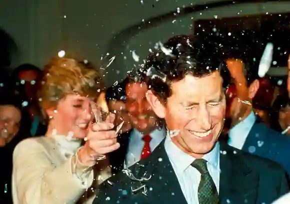 La princesse Diana brise une bouteille en verre sur la tête de son mari aux studios Pinewood pour assister au tournage des derniers films de James Bond, le 11 décembre 1986.