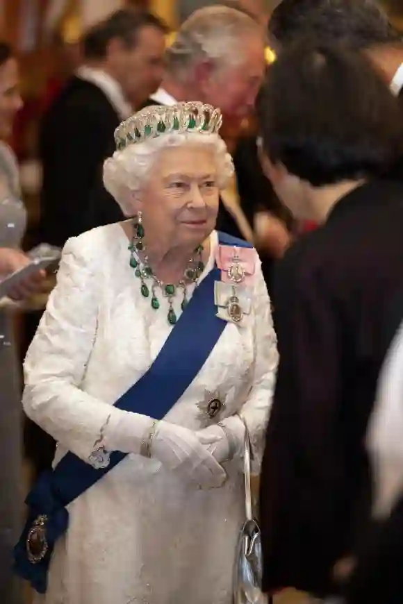 Queen Elizabeth II talks to guests at an evening reception for members of the Diplomatic Corps at Buckingham Palace on December 11, 2019 in London, England