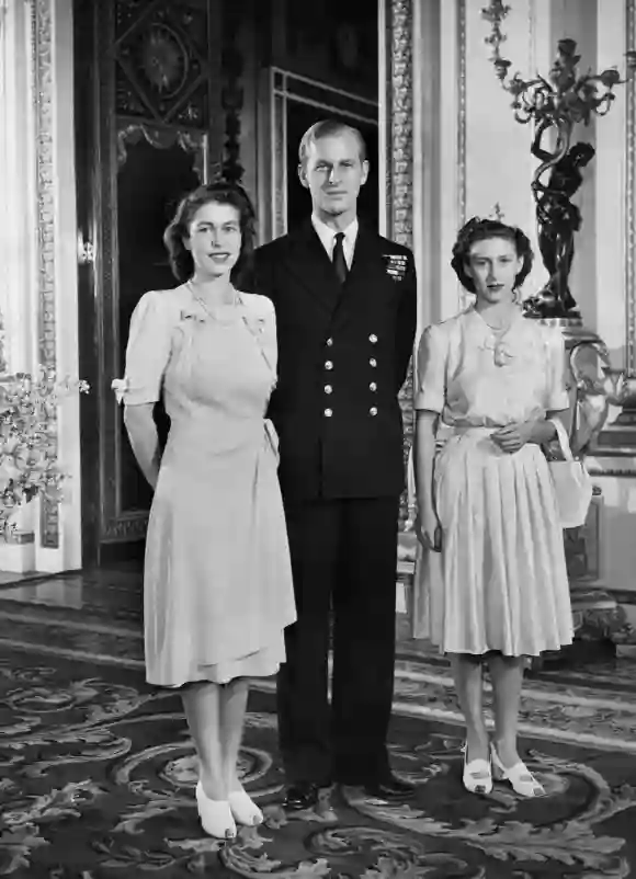 La princesa Isabel (futura reina Isabel II), Philip Mountbatten (también duque de Edimburgo) y la princesa Margaret posan en el Palacio de Buckingham el 9 de julio de 1947 en Londres, el día en que se anunció oficialmente su compromiso.