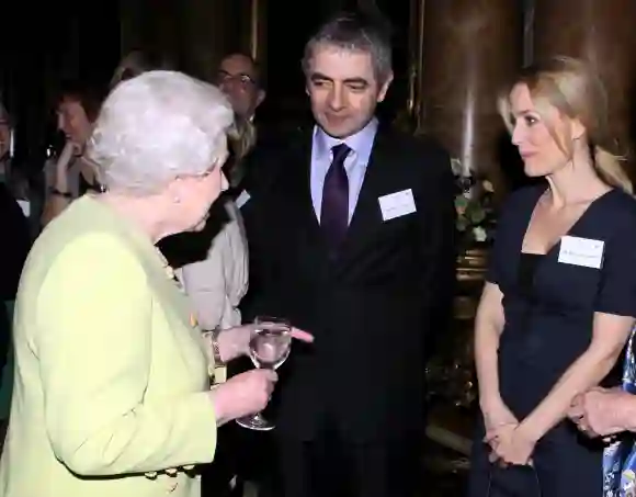 La Reine Elizabeth II rencontre l'acteur Rowan Atkinson et l'actrice Gillian Anderson lors d'une réception, le 14 février 2012.