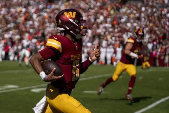 Le quarterback des Washington Commanders Jayden Daniels (5) court le ballon lors d'un match contre les Clevland Browns au Northwes