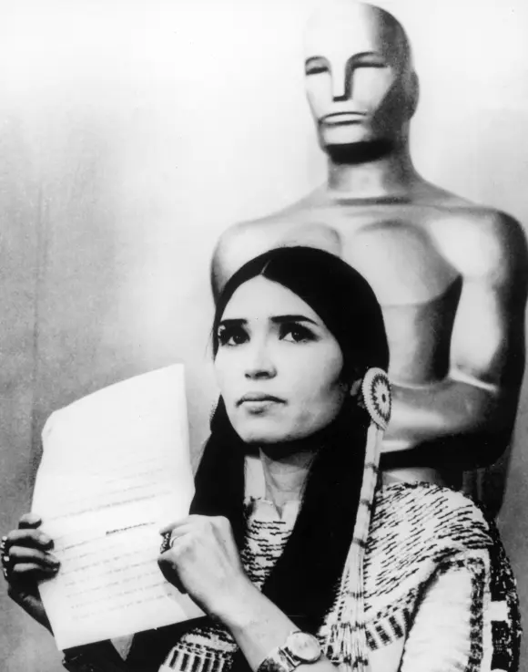 Sacheen Littlefeather holds a written statement from actor Marlon Brando refusing his Best Actor Oscar on stage at the Academy Awards