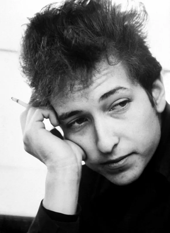 Portrait  of  singer-songwriter  Bob  Dylan  holding  a  cigarette,  head  resting  on  hand,  1964