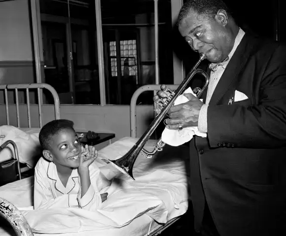 Syndication: The Tennessean The sound of Satchmo delights Victor Mitchell, left, 8, as the world famed jazzman Louis Ar