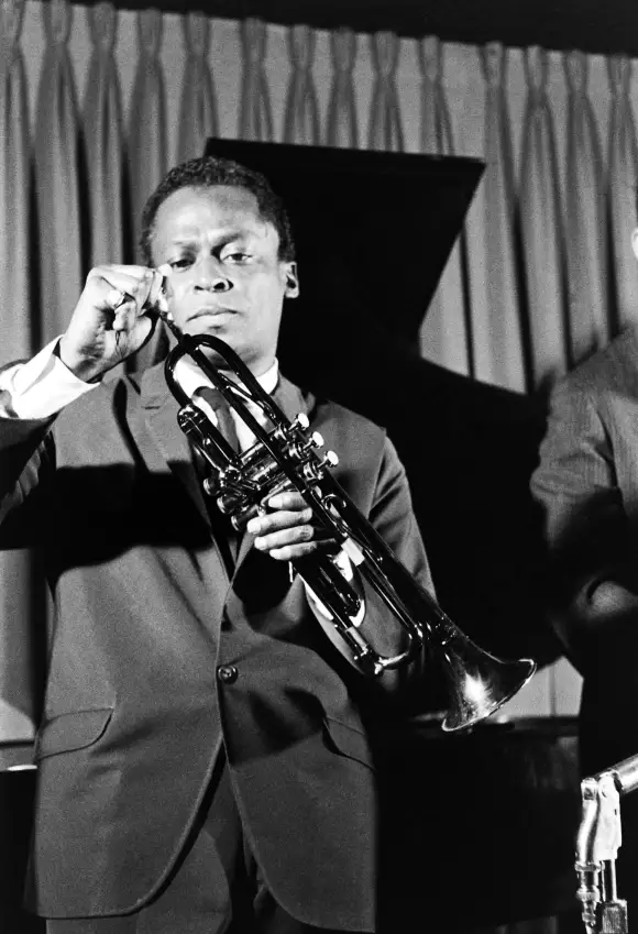 Jazz  musician  Miles  Davis  adjusting  the  mouthpiece  of  his  trumpet.Robert  W  Kelley/The