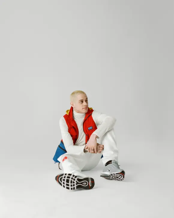 Comedian  Pete  Davidson,  sitting  on  the  floor,  wearing  a  Polo  Ralph  Lauren  vest  over  a