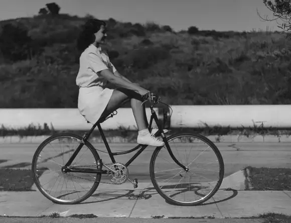 Actress  Rita  Hayworth  trying  out  some  new  tricks  on  her  bicycle  during  10-mile  trip  w.