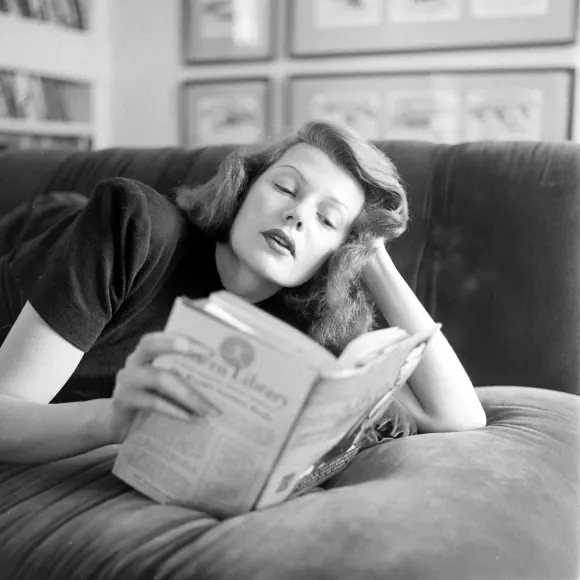 American  actress  Rita  Hayworth  (born  Margarita  Cansino,  1918  -  1987)  lies  on  a  couch  a