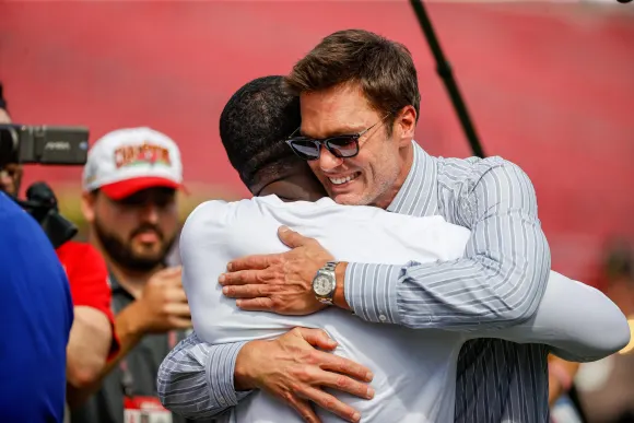 September 29, 2024, Tampa, Florida, USA: Former Bucs player Tom Brady hugs and greets Tampa Bay Buccaneers linebacker La