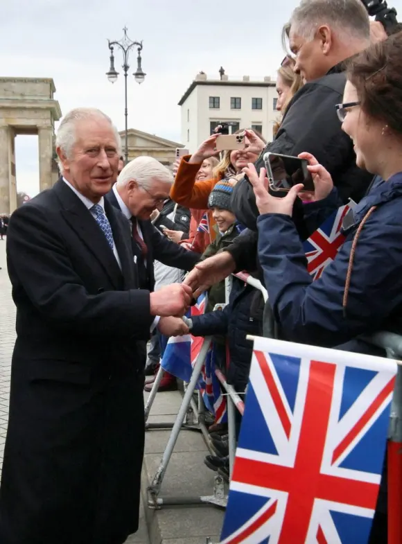King Charles III talks to fans in front of the Brandenburg Gate